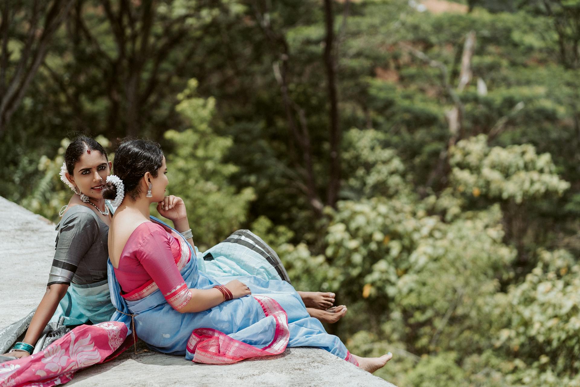 Two women in traditional saris sitting outdoors in Hatton, Sri Lanka, enjoying a serene moment.