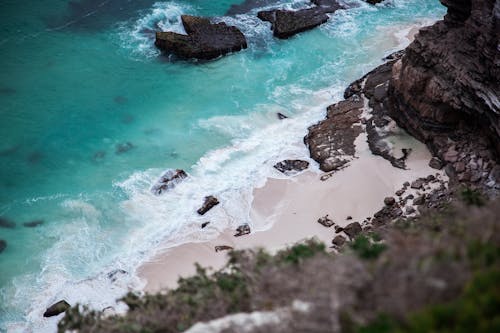 Fotografia De Paisagem De Formações Rochosas Negras Perto Do Corpo D'água