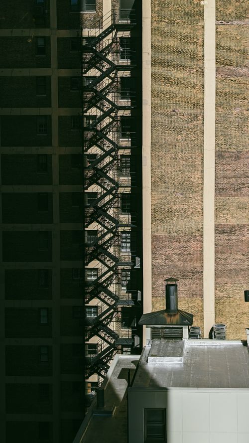 Free Elevated view of a city's brick building with fire escape, showcasing urban architecture. Stock Photo