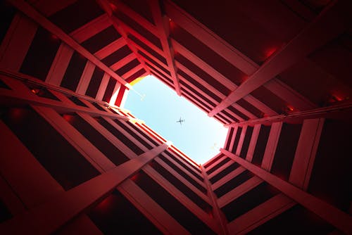 Photographie De Faible Angle De Bâtiment Montrant Un Avion Dans Le Ciel