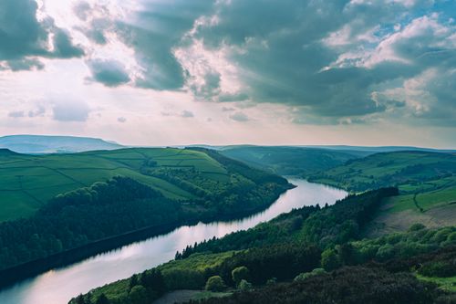 Free Majestic English landscape with lush hills, forests, and a winding river under dramatic skies. Stock Photo