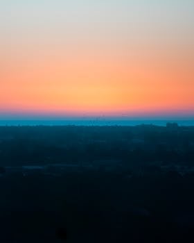 Stunning view of Adelaide city skyline with a vivid sunrise, showcasing a tranquil morning atmosphere.