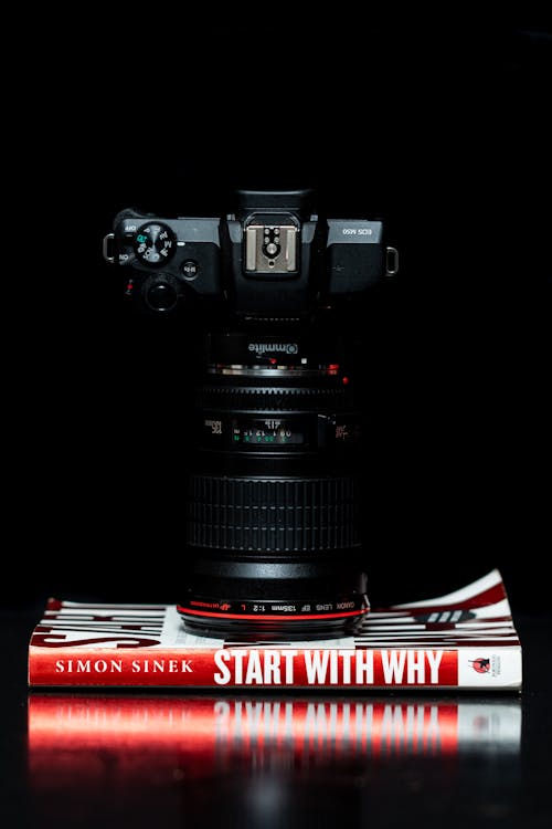 Black Dslr Camera on Start With Why by Simon Siner Book