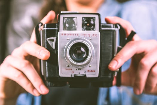 Capturing nostalgia with a classic Brownie Twin 20 camera held gingerly in hands.