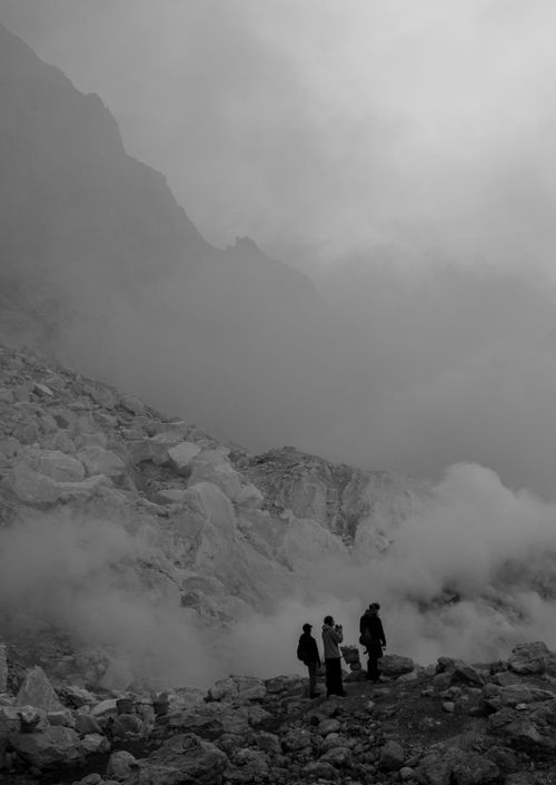 Free Three adventurers explore a foggy, rocky mountain with an air of mystery and adventure. Stock Photo