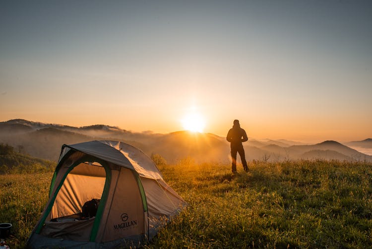 Silhouette Of Person Standing Near Camping Tent