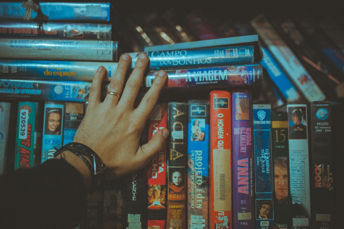 Reaching for a favorite movie title from a vintage VHS collection