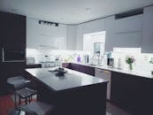 现代厨房内部配有白色时尚橱柜和岛台，非常适合极简主义美学