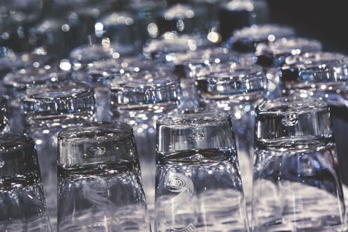 Free Close-up of crystal clear upside-down drinking glasses with an elegant reflection. Stock Photo