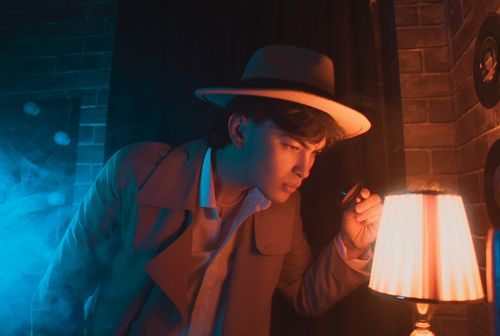 Free Stylish man in hat and trench coat investigating with lamp and magnifying glass. Stock Photo