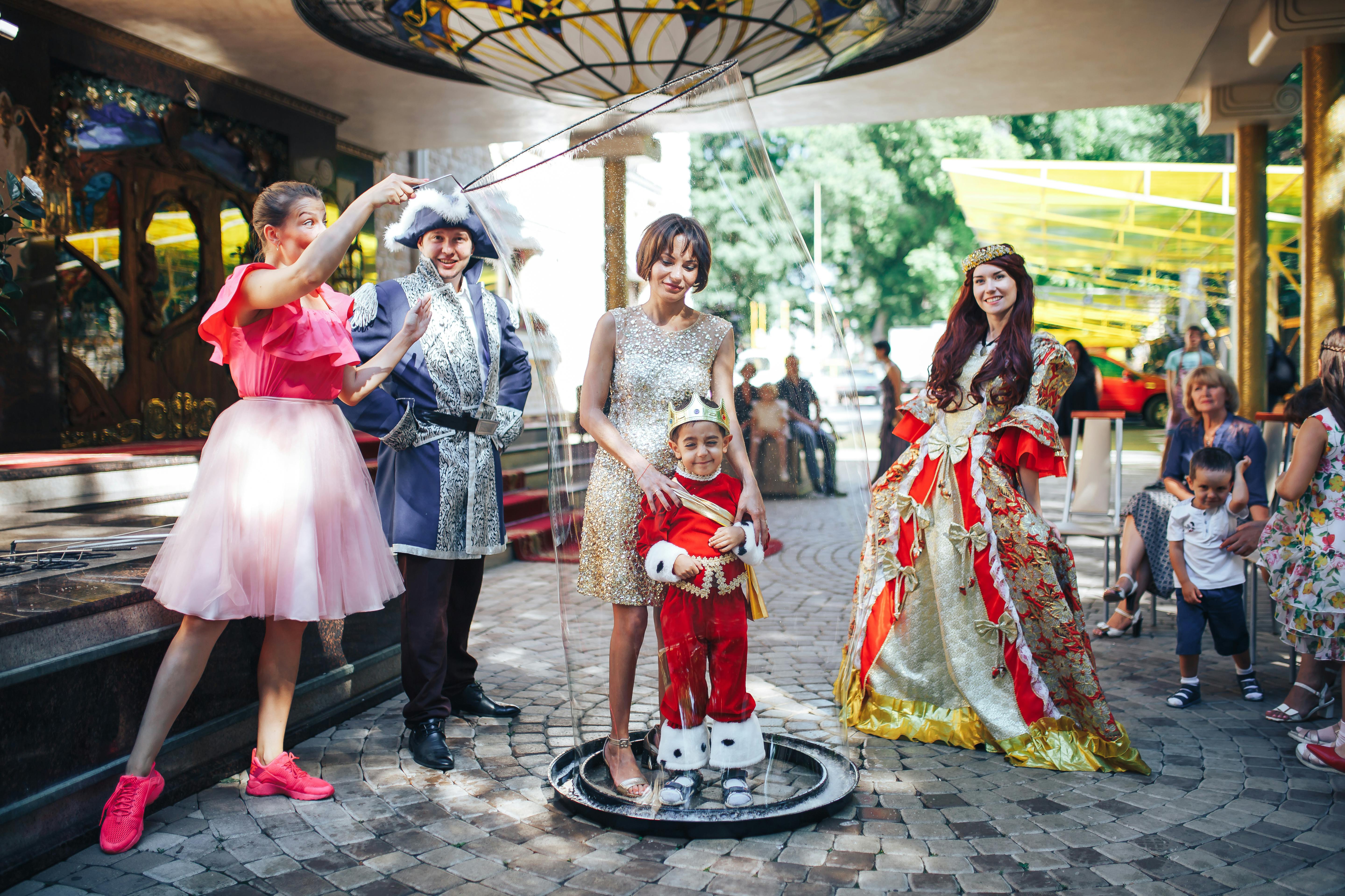 一群身着缤纷服装的人们在户外享受角色扮演活动，现场洋溢着节日气氛