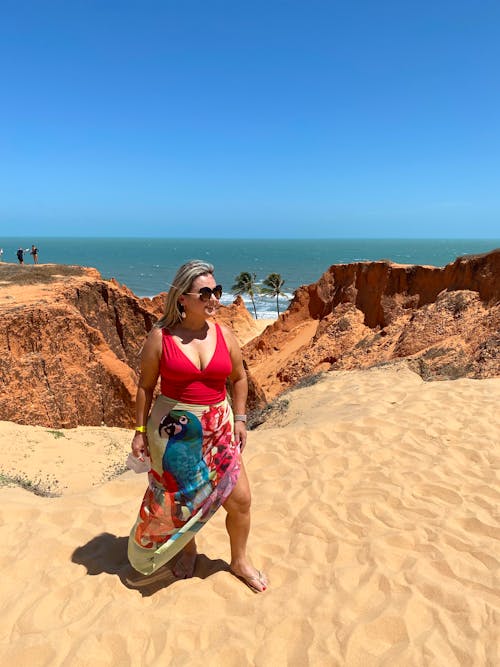 A woman in a colorful dress standing on the beach