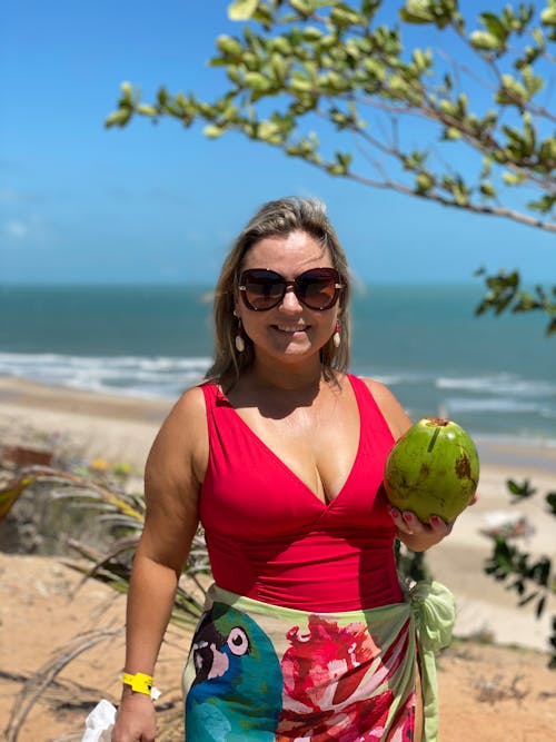 A woman in a red bikini holding a coconut
