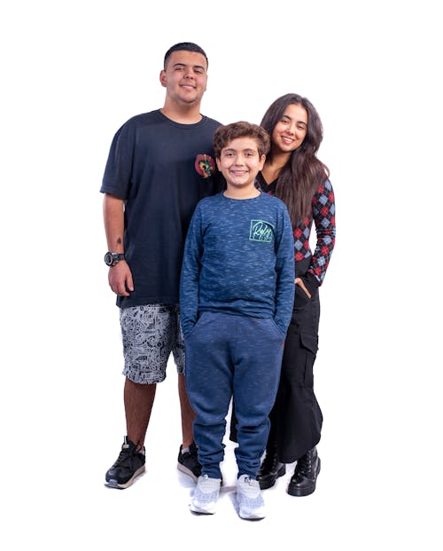 A family poses for a photo in front of a white background