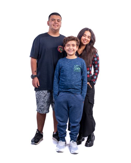 Free Joyful family posing in a studio against a white backdrop. Stock Photo