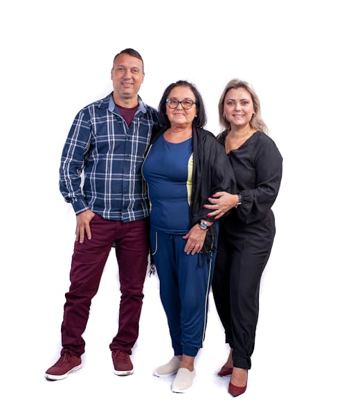 Three people posing for a photo in front of a white background