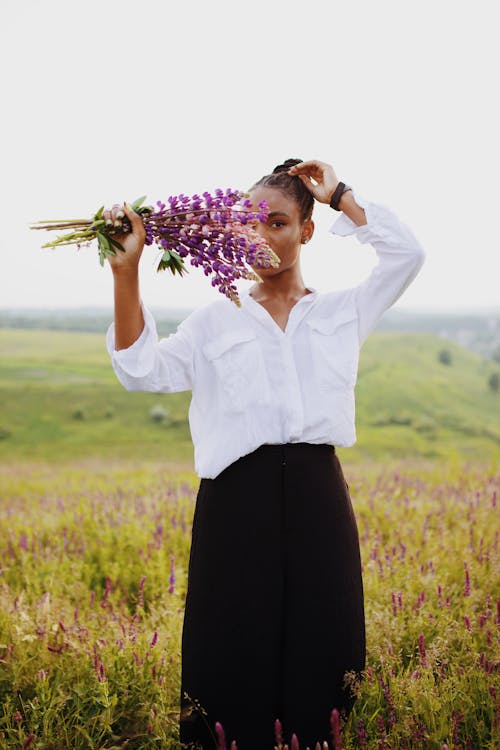 Photo of Woman Holding Purple Flowers