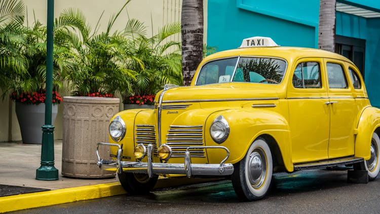 Photo Of Yellow Taxi Parked Near Sidewalk