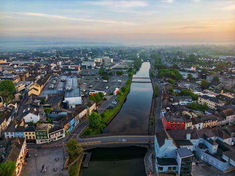 A captivating aerial view of a picturesque town with a river and colorful buildings at dusk.