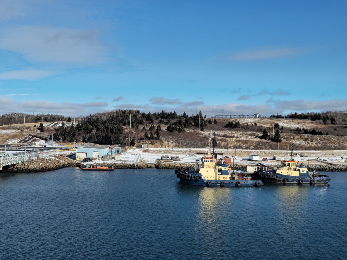 Tugboat moored at a quiet coastal shore