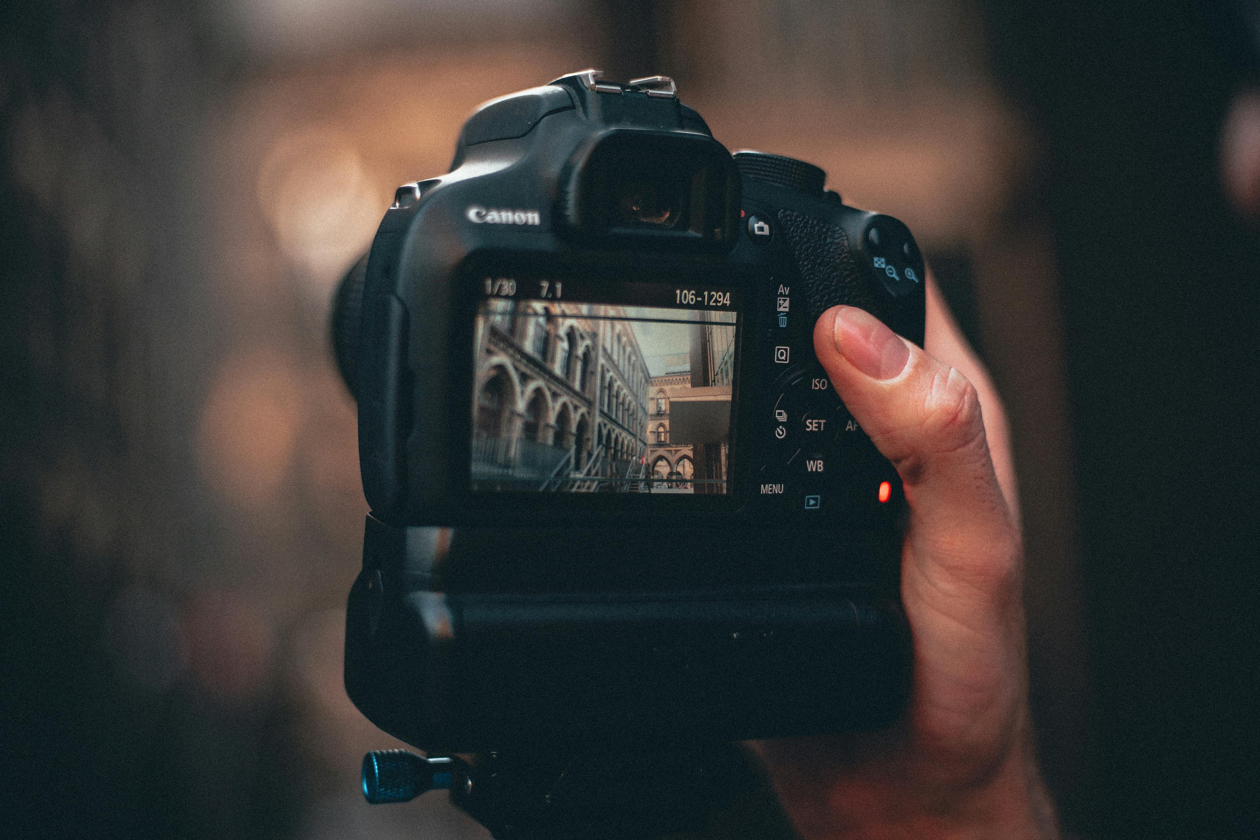 close up photo of person holding dslr camera