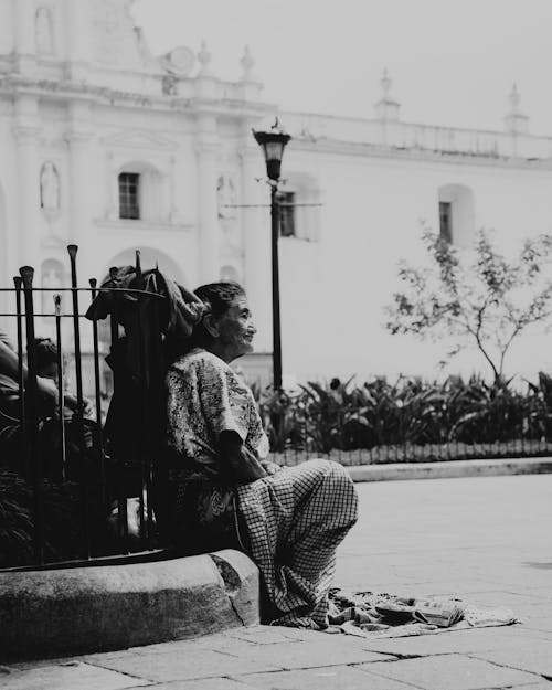 A woman sitting on the ground in front of a church