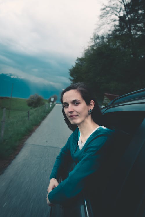 Free Woman on a Black Vehicle Looking Out the Window Stock Photo