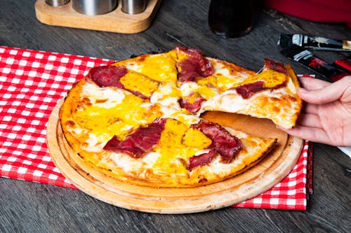 A person is cutting a pizza with a knife