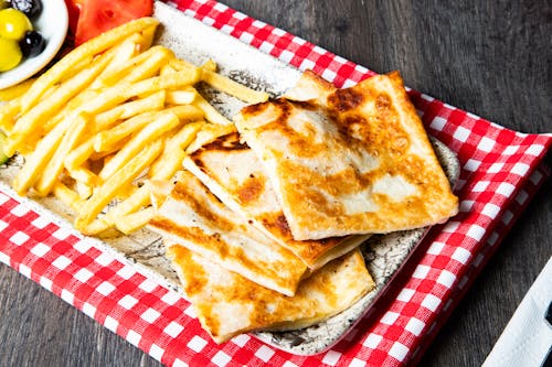 A plate with french fries and cheese quesadillas