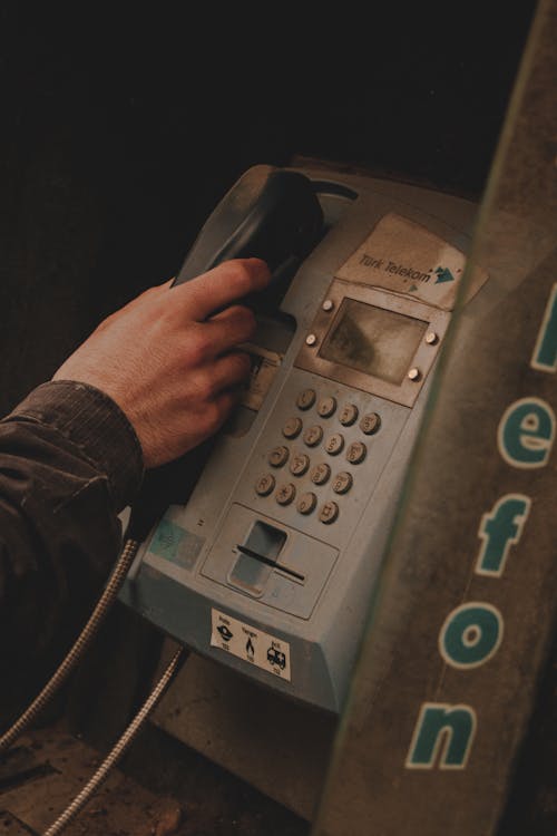 A person is using a pay phone to call someone