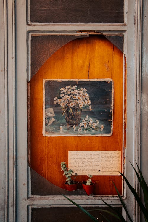 A framed picture of flowers on a wooden door