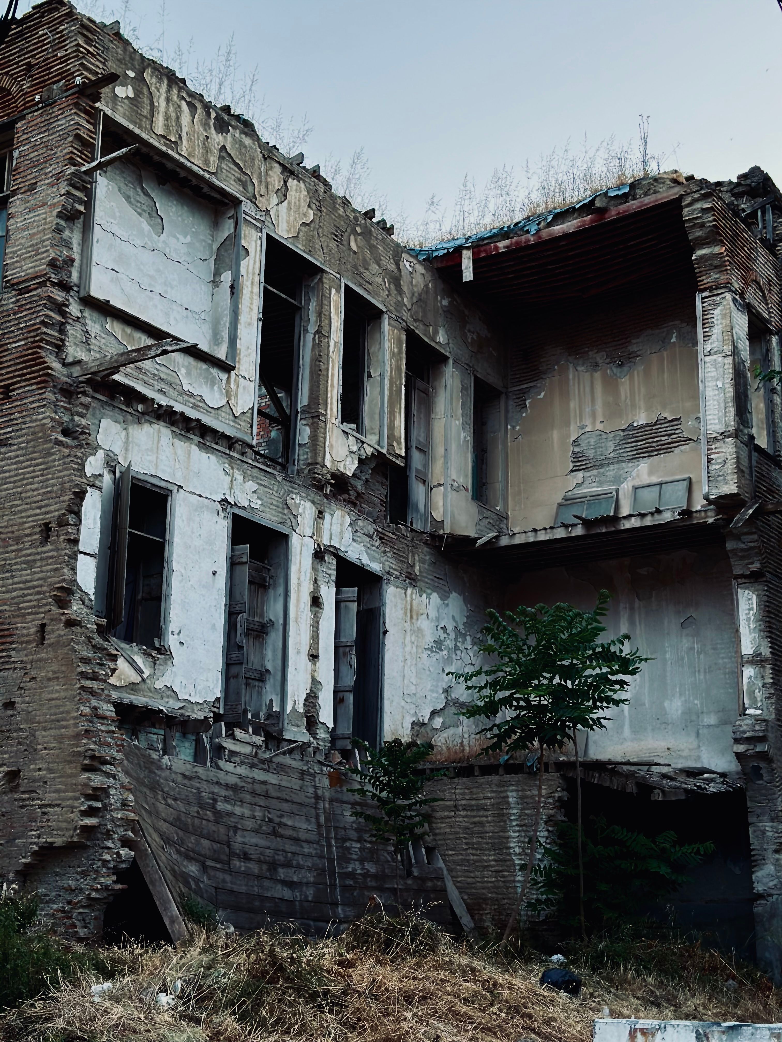 An eerie view of a decaying, abandoned building showcasing nature's reclamation.