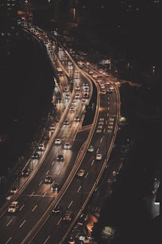 A top-down view showcasing traffic on a lit urban expressway at night.