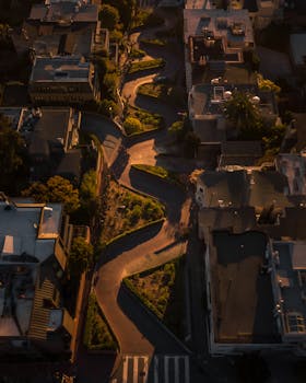 旧金山日出时分，从空中俯瞰伦巴第街，可见房屋与绿地之间蜿蜒的标志性道路