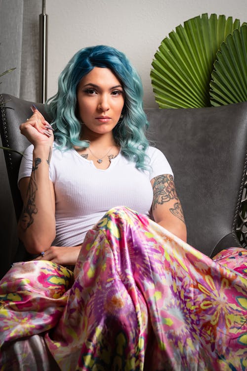 A woman with blue hair sitting on a couch