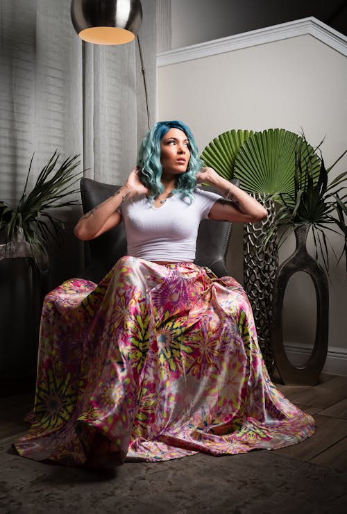 A woman with blue hair sitting on a chair