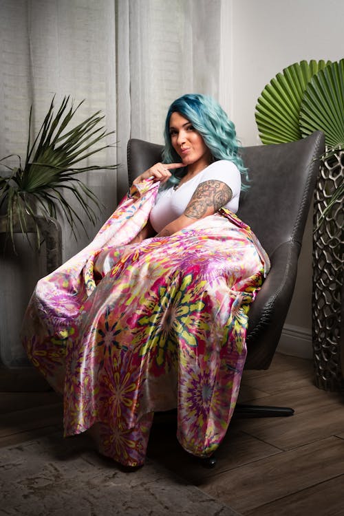 A woman with blue hair sitting on a chair