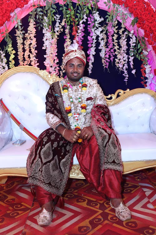 A man in traditional attire sitting on a throne