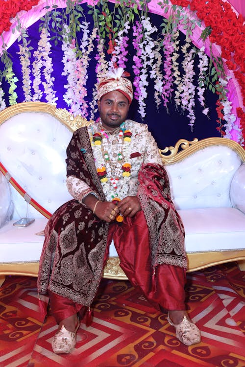 A man in traditional attire sitting on a couch