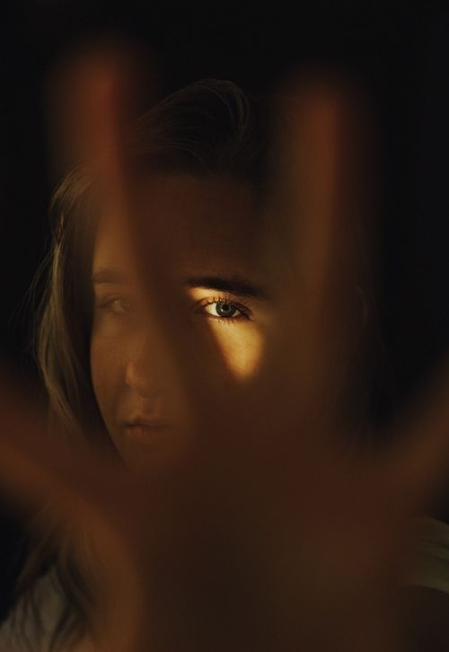 Free A close-up portrait of a woman with dramatic lighting emphasizing her eye, creating a mysterious mood. Stock Photo