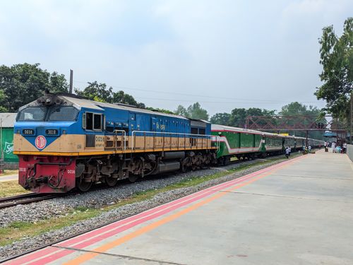 Free A blue and green train on the tracks at an outdoor station during the day. Stock Photo