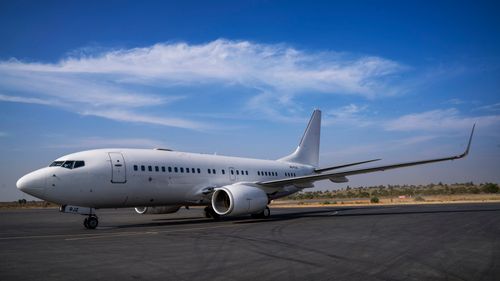 Free A large white commercial airplane on the runway under a clear blue sky, ready for departure. Stock Photo
