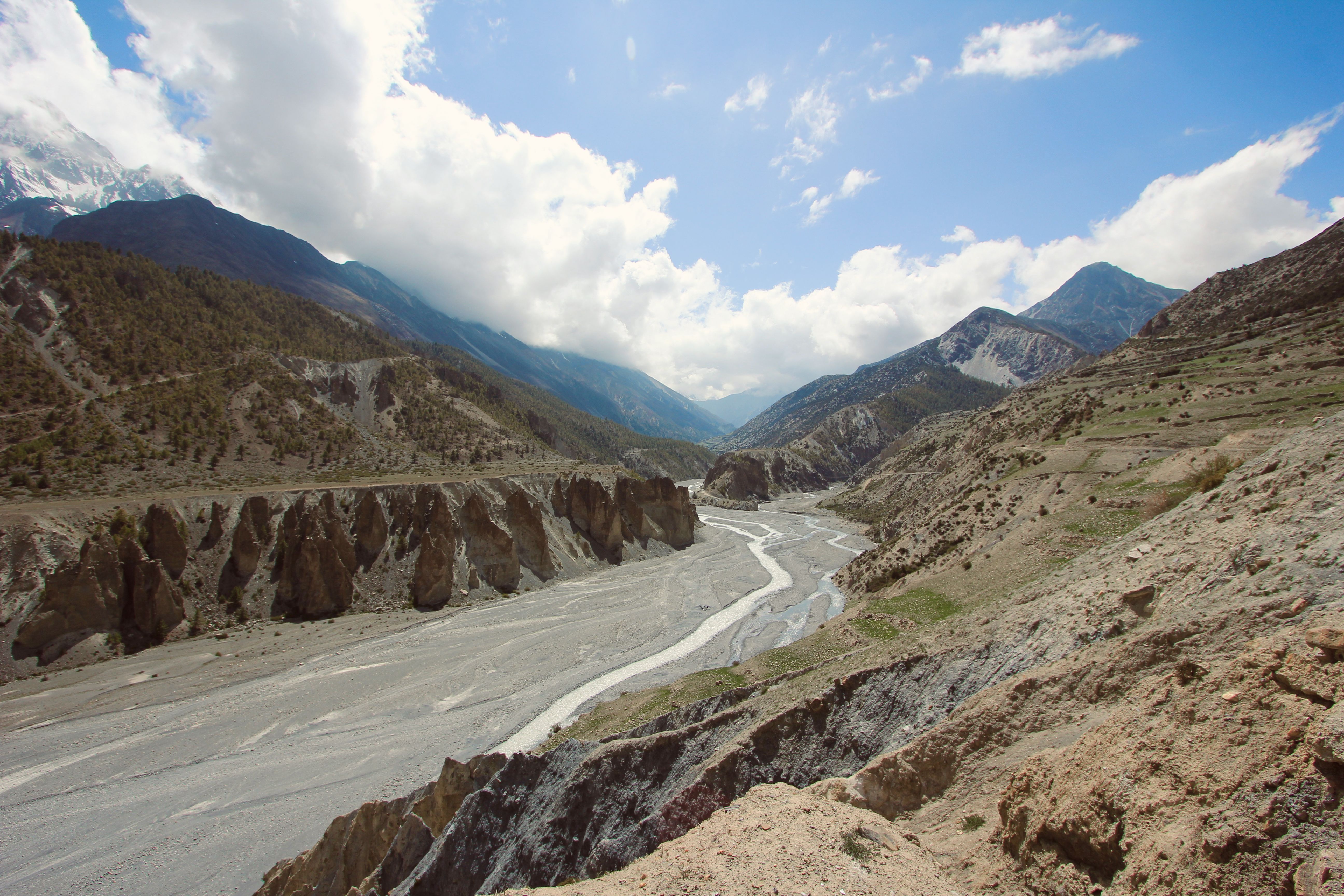Breathtaking landscape of Himalayan mountains and winding river under a bright sky.