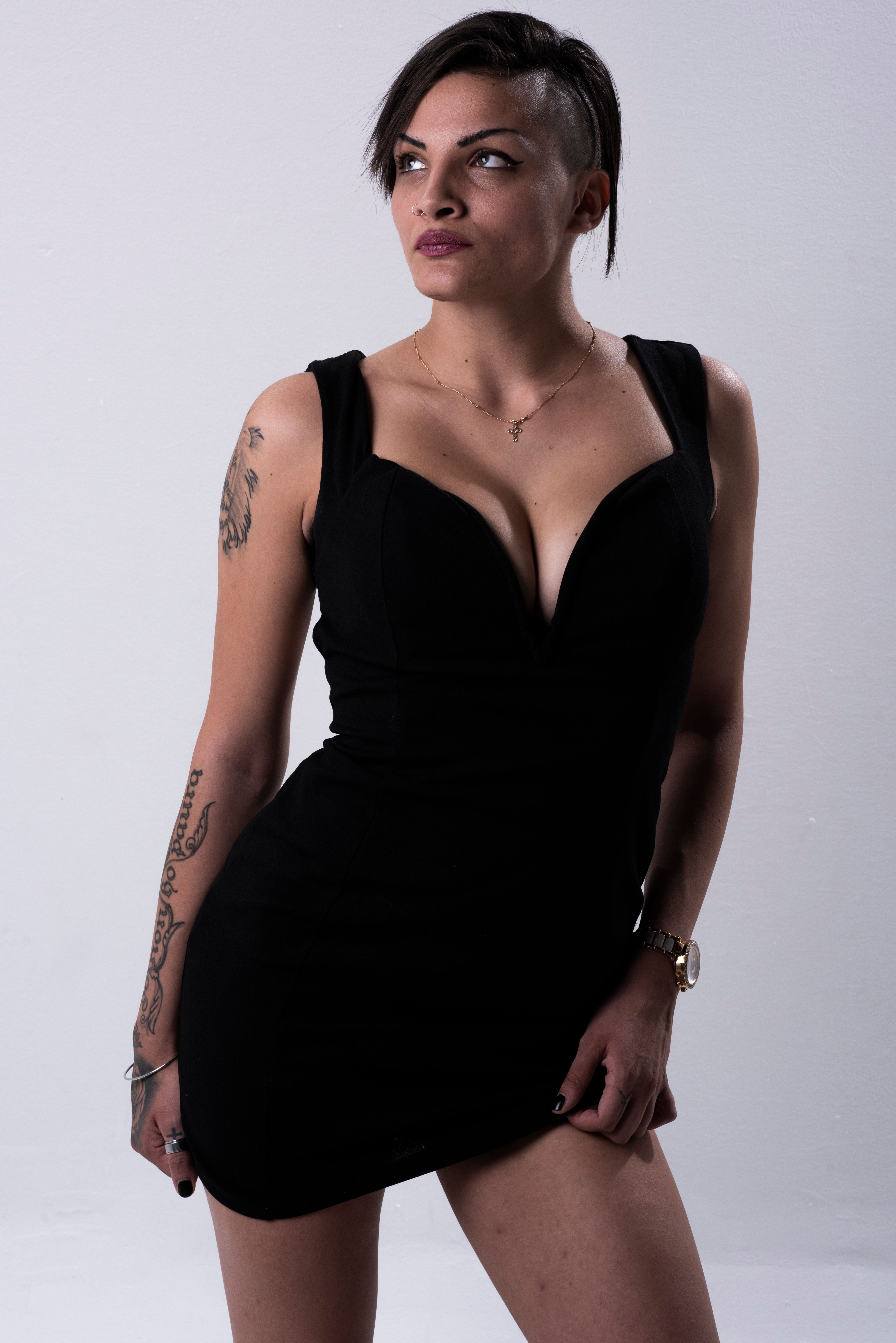 Stylish portrait of a model wearing a black dress in a studio setting, emphasizing modern fashion.