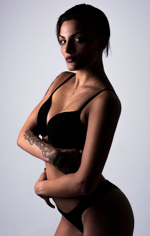 A woman in a black bra and underwear posing