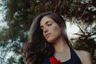 在自然环境中，阳光轻柔地照亮了一位长发女性的优雅肖像，展现了完美生活方式与时尚主题