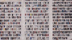 一张高角度航拍照片中，大型室外停车场里停着一排排汽车