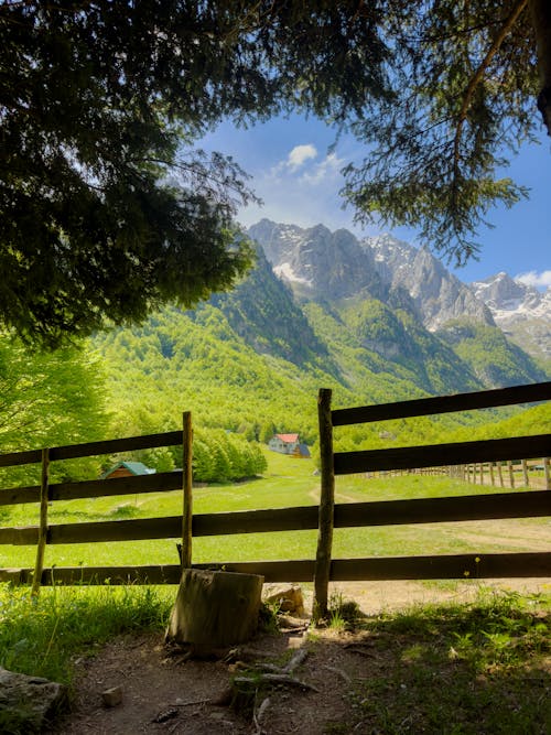 A wooden fence and a mountain range in the background