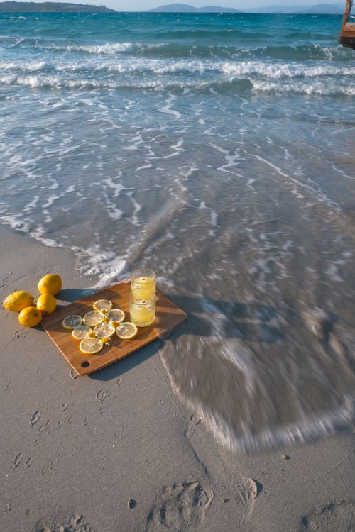 Free Refreshing lemonade with lemons by the beach, capturing the essence of a sunny day by the sea. Stock Photo
