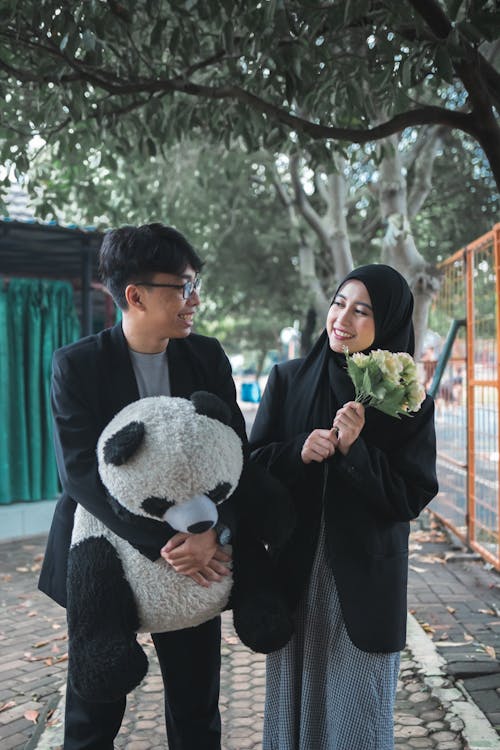 A man and woman holding a panda bear